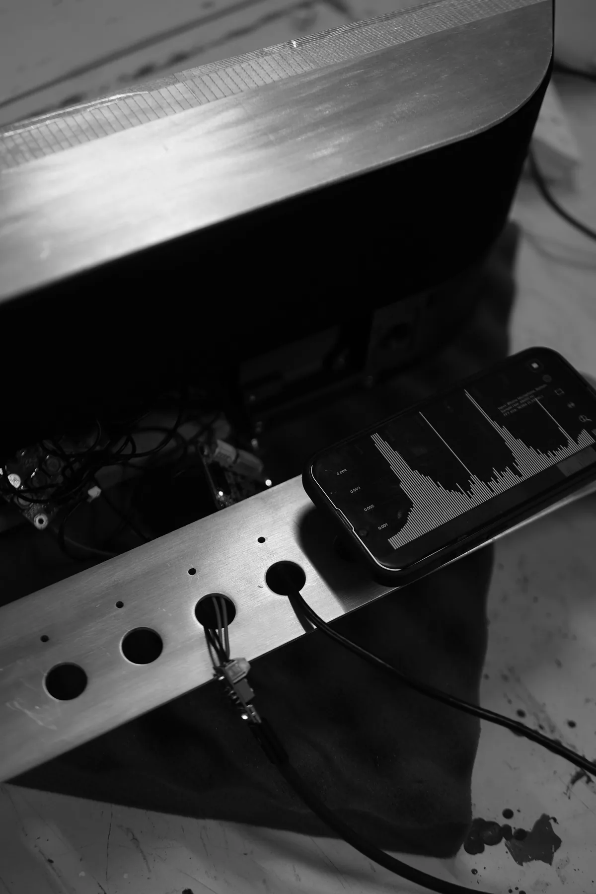 Radio* prototype on the workshop bench: brushed aluminium panel, wiring and a phone running an audio analyser